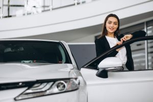 Woman choosing a car in a car showroom