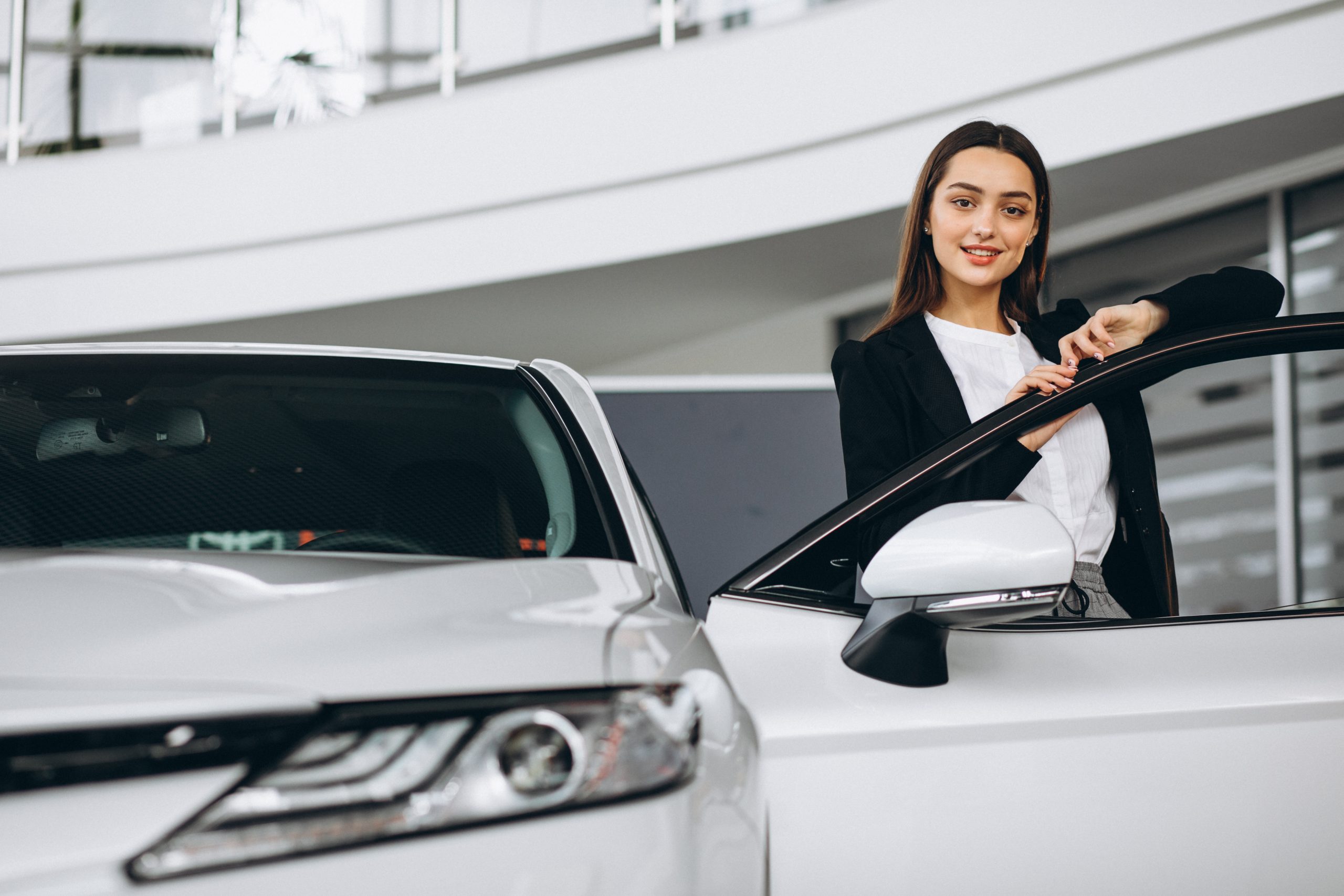 Woman choosing a car in a car showroom
